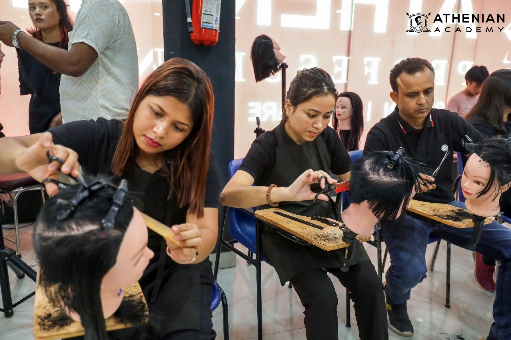 Athenian Academy students practicing precision haircutting on mannequins